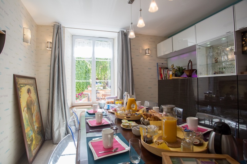 We see the breakfast table set in the Linterfaces dining room, garnished with pastries and baguettes from the baker, homemade products, fruits and fruit juices and many other sweet and savory things.