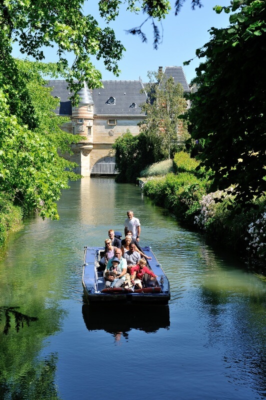 We see a group of people taking part in the Eau’dyssée boat trip during the day in Châlons-en-Champagne